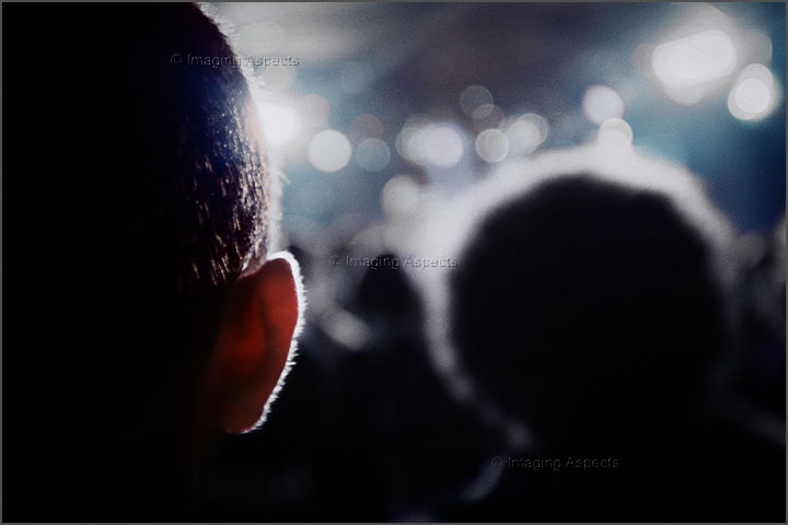 The ear of an audience member glows as the stage lights pulse and Mogwai play at the Prince of Wales Hotel in St. Kilda, Victoria, Australia.