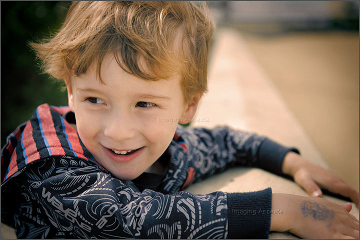 Candid photo of a smiling three and a half year old boy on the Mordialloc foreshore.
