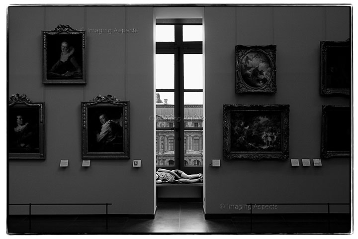 A school boy sleeps on a window sill at Le Louvre in Paris, France.
